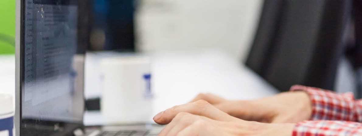 Photo of man typing on a laptop computer.