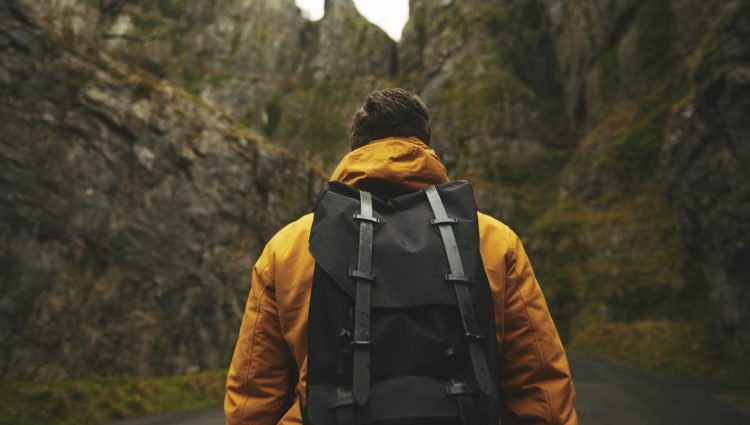 mage shows man with a backpack walking in the mountains