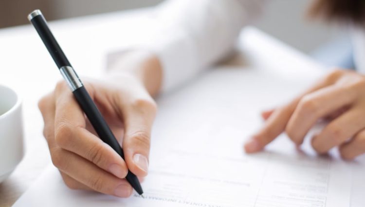 close up of a woman writing on paper