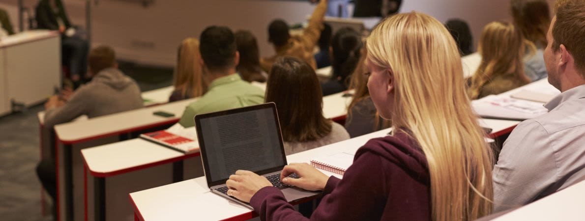 Student on laptop in lecture theatre