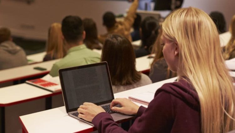 Student on laptop in lecture theatre