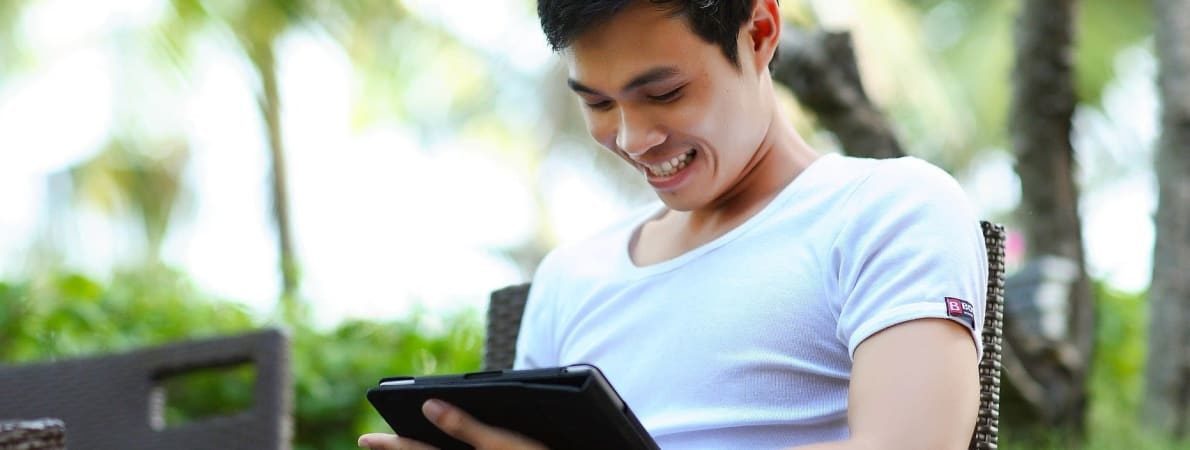 Student smiling using iPad