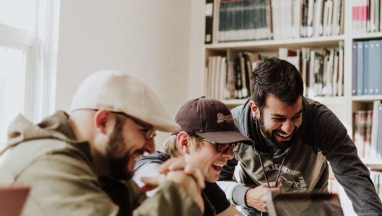 A group of students working on laptops and laughing all together