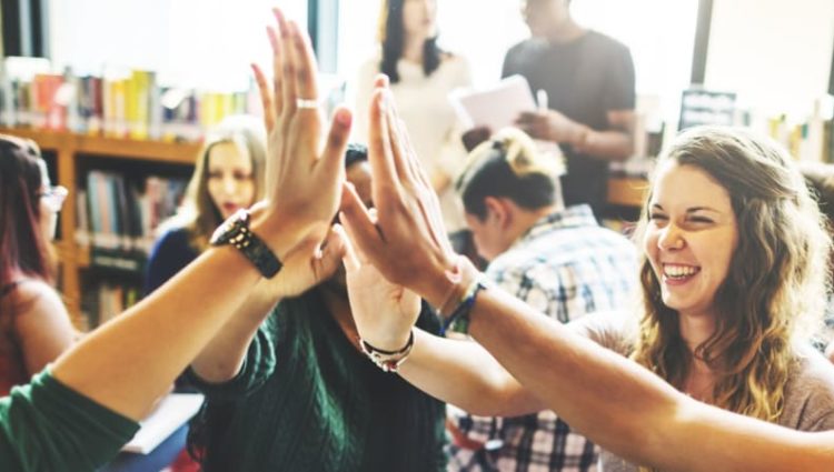 Students holding hands up to high-5