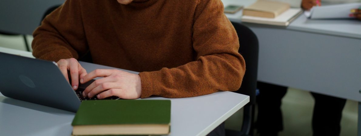 student working on laptop in an exam setting