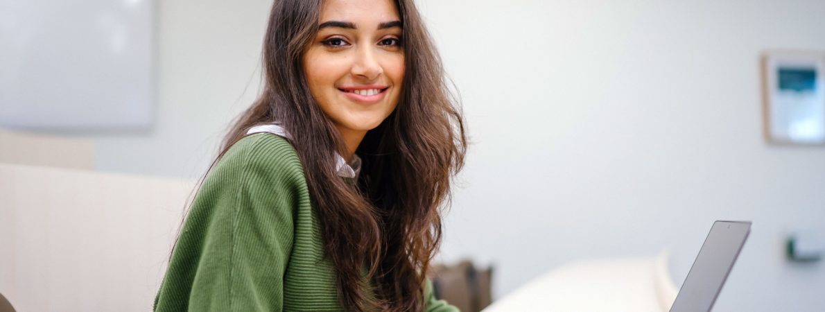 Woman smiling as she works on her laptop