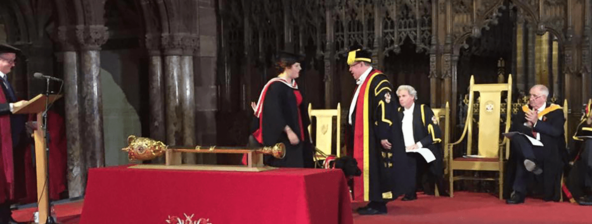 Elin and Jazzy on stage receiving degree from vice chancellor