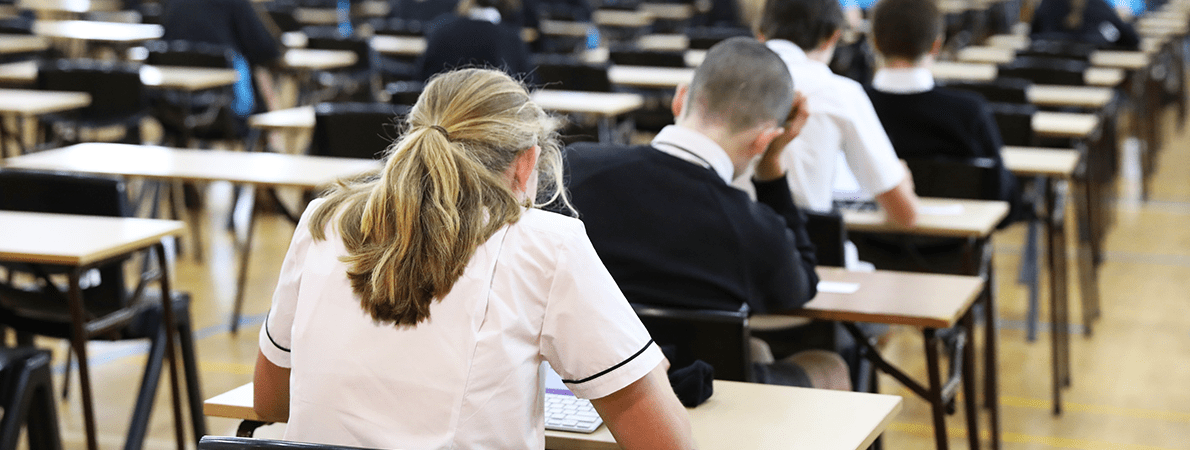 Examination room set up with tables and desks in a high school hall.