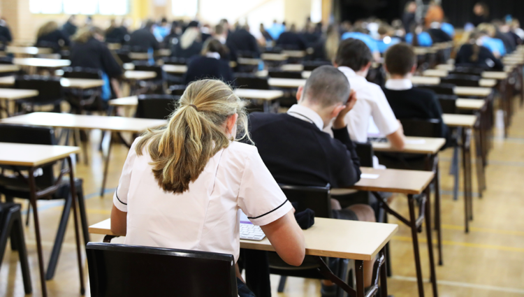 Examination room set up with tables and desks in a high school hall.