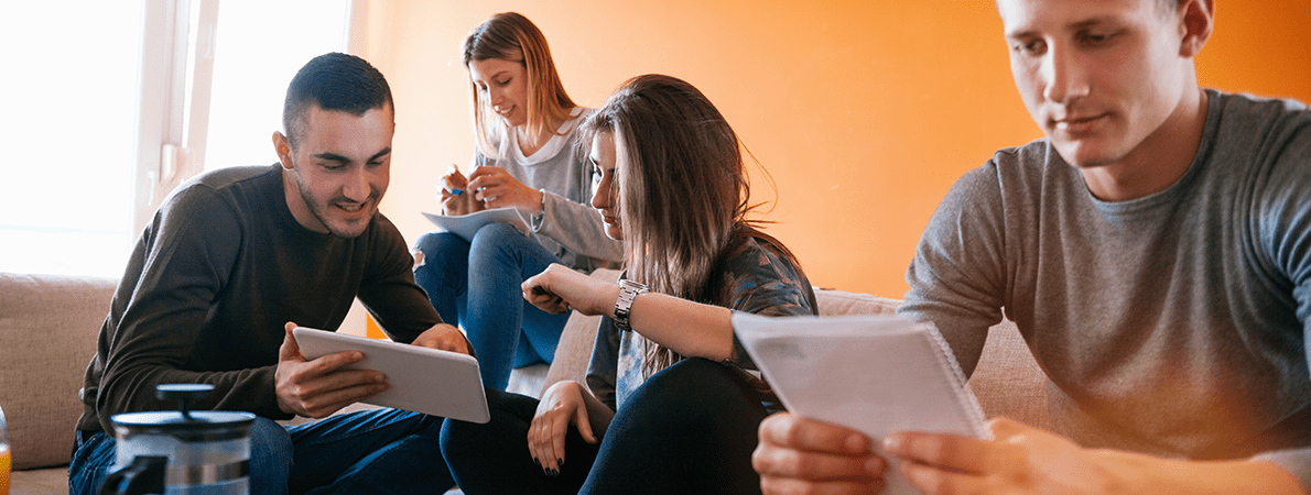 Friends studying together in university halls living room