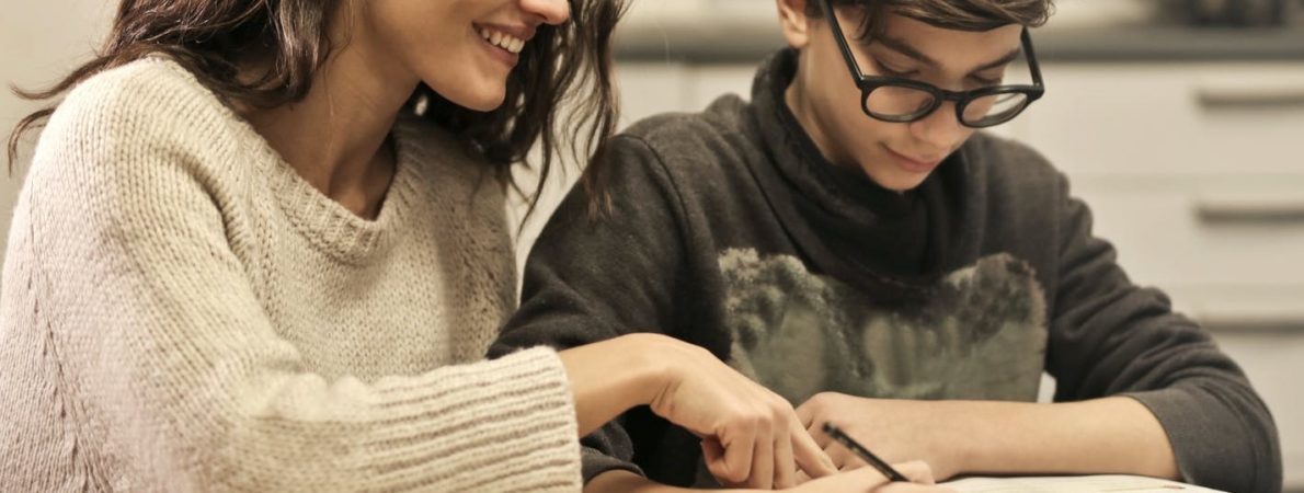 Woman helping young boy study