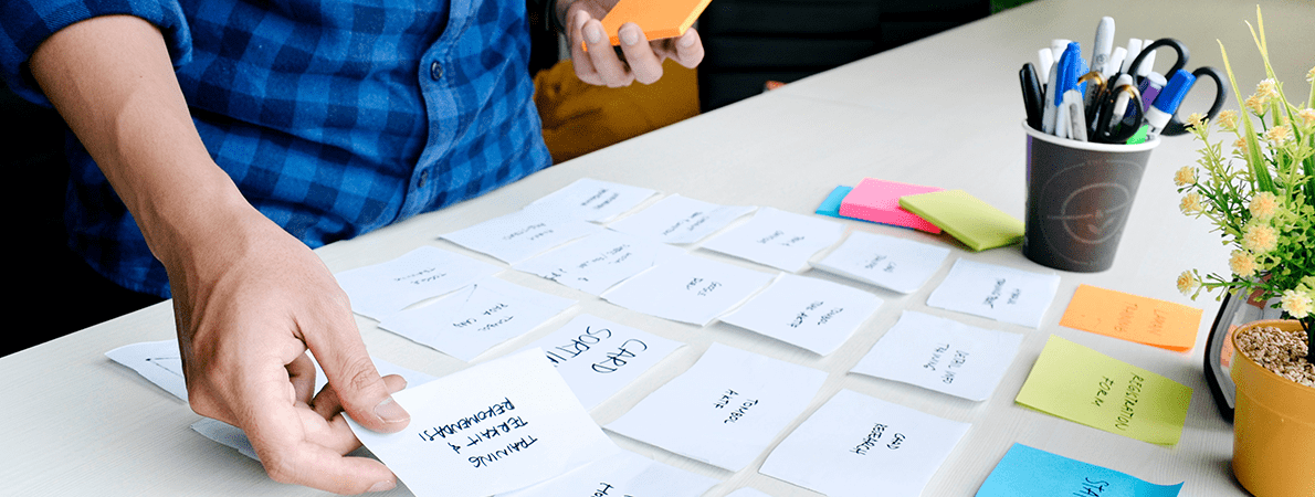 Man holding placing post-it notes on a table