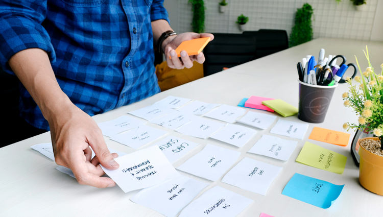 Man holding placing post-it notes on a table