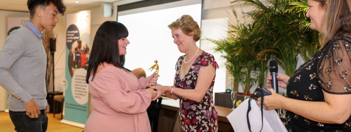 Frances Powell presenting the award for outstanding volunteer to Kerrie, Wayne Jordan's daughter, watched by Wayne's stepson Jacob and Emma Hughes from TPT