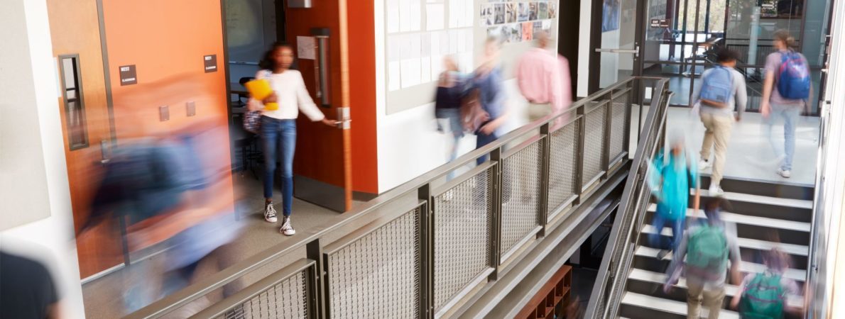 Busy college corridor with students going up stairs