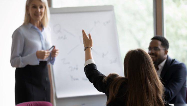 Training session. One person at flipchart. A woman has hand up