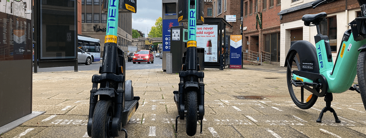 Tier e-scooters and e-bike parked in marked bay