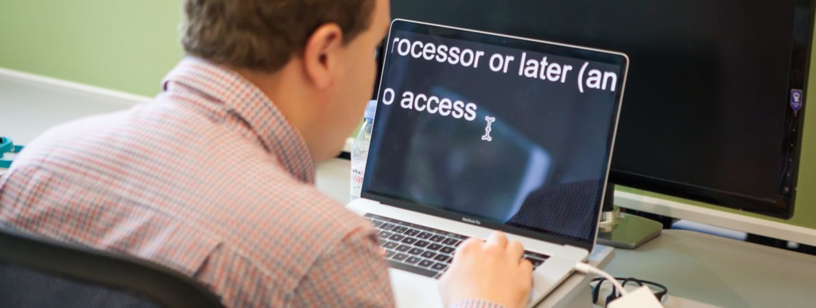 Man working on a laptop with accessible text