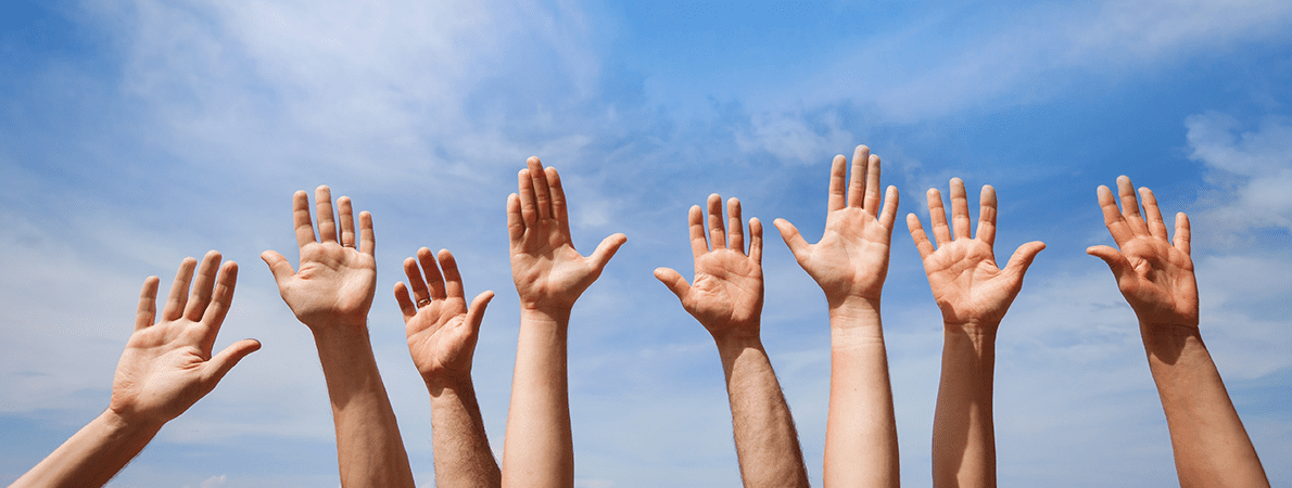 Four pairs of hands raised towards a blue sky.