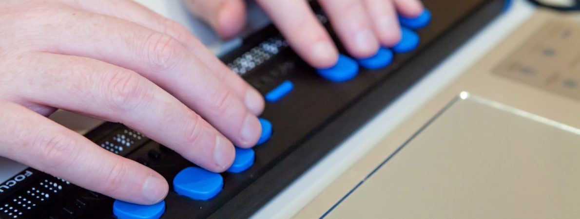 close up picture of a person using a braille keyboard