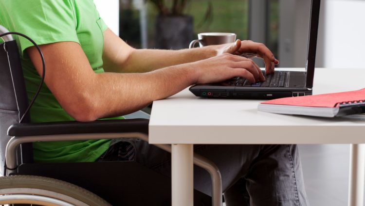 Disabled student in a wheelchair working on a laptop