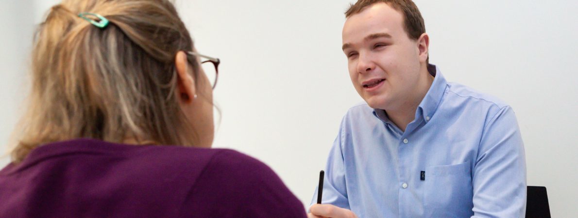 a visually impaired person chatting to a woman