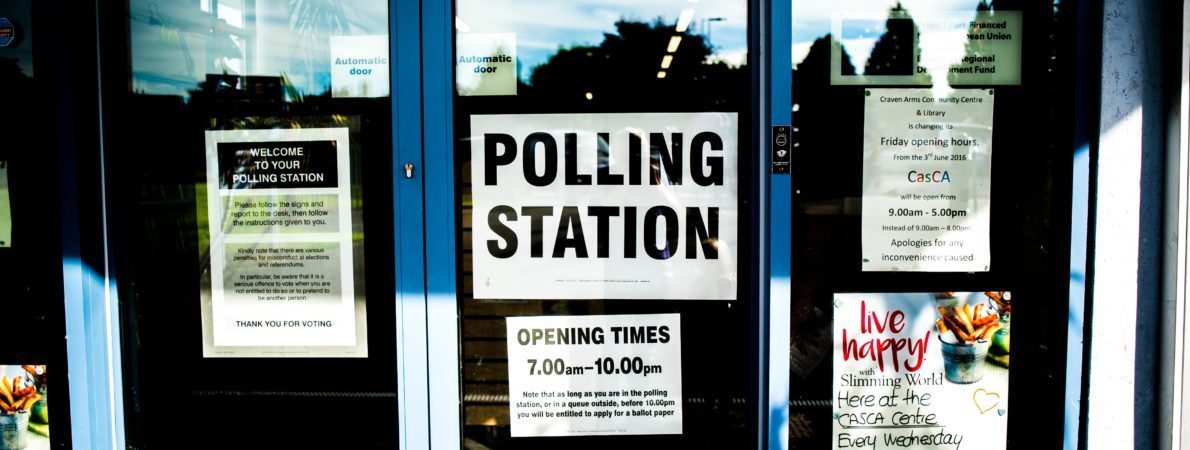 Three glass doors with a sign that says 'Polling Station'