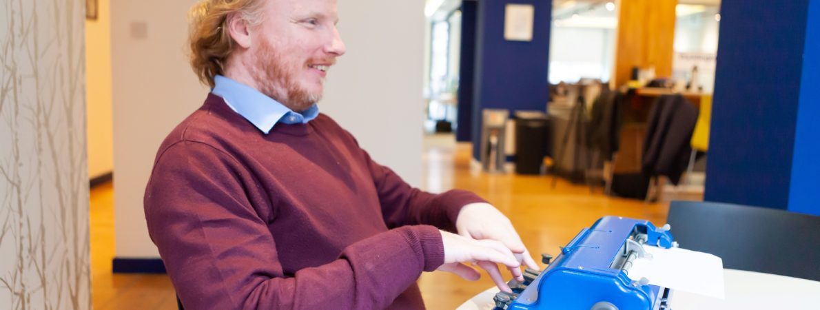 A visually impaired person using a typewriter in braille