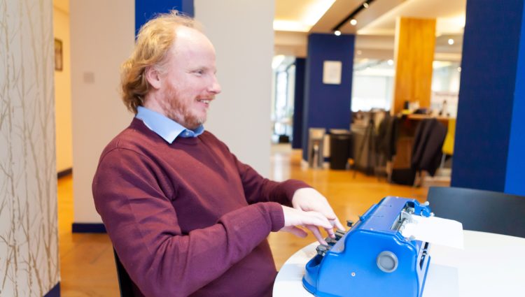 A visually impaired person using a typewriter in braille