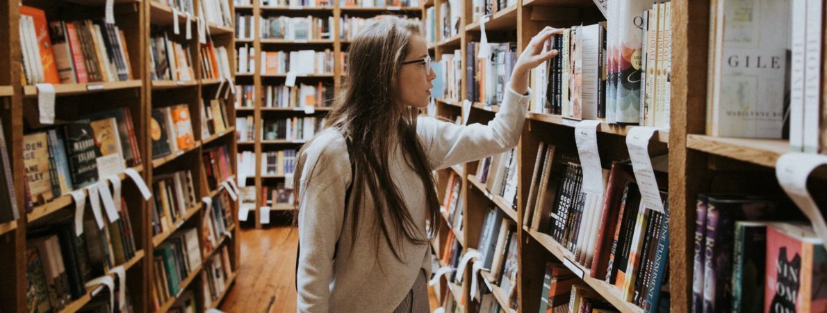 A young woman looking for a book in a library