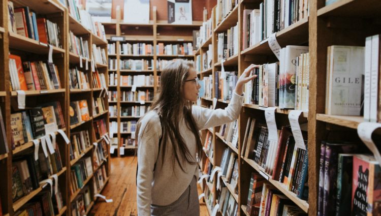 A young woman looking for a book in a library