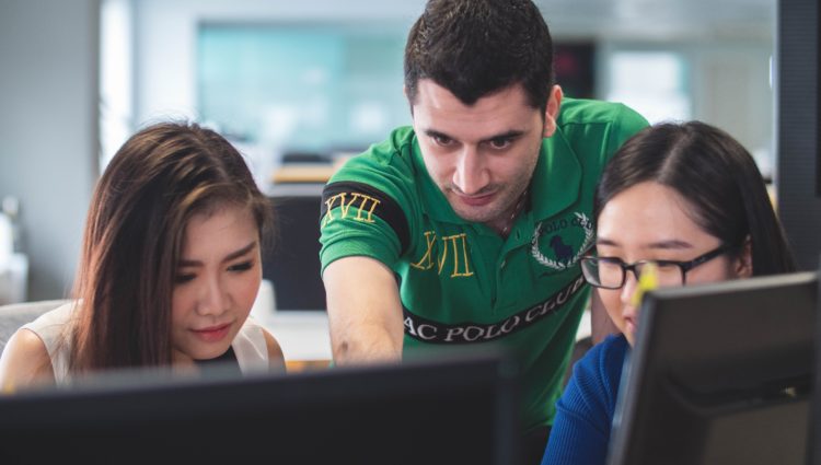 Three students working together with their laptops