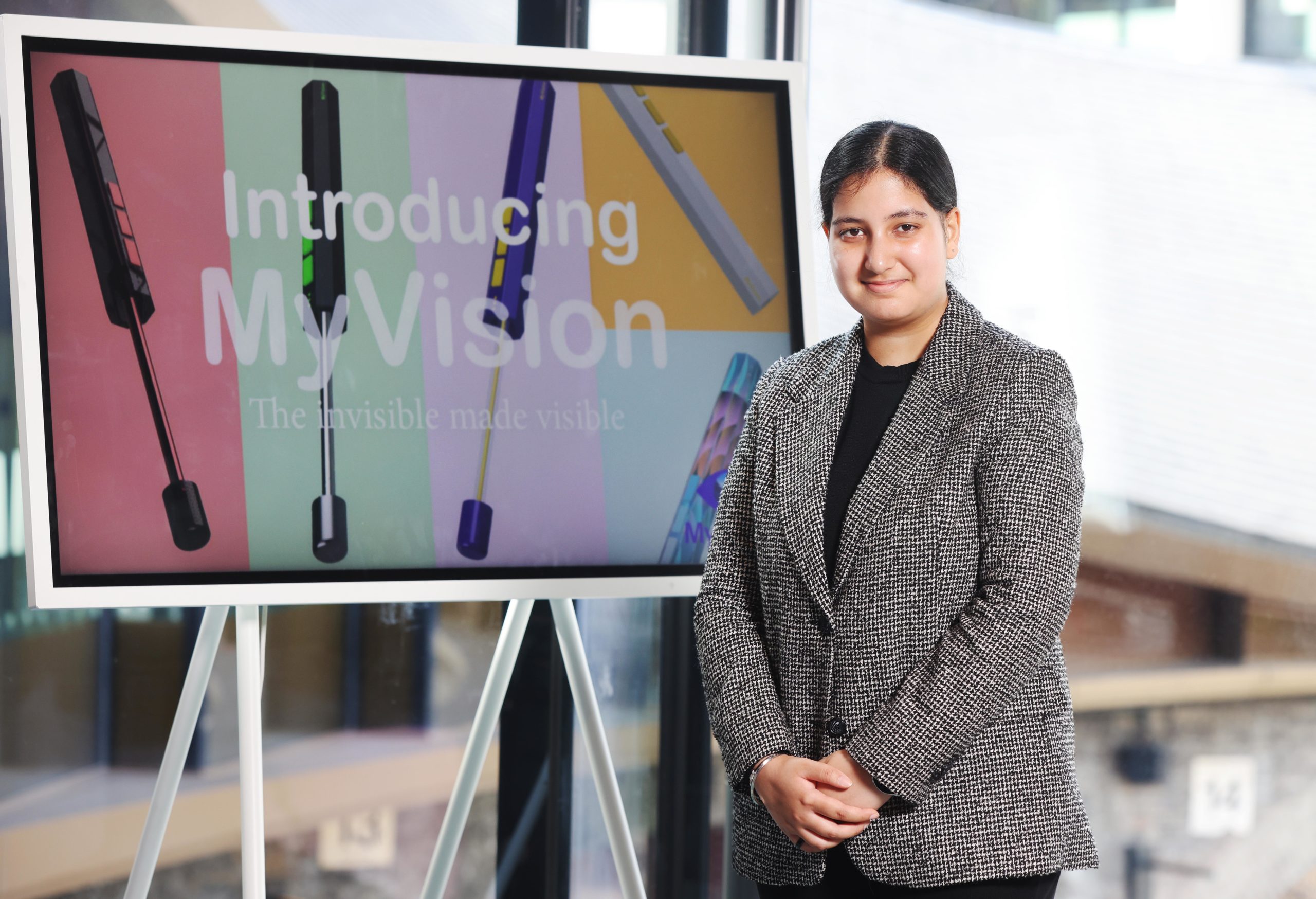 Picture of Ramneek smiling in front of a screen that says 'Introducing My Vision'