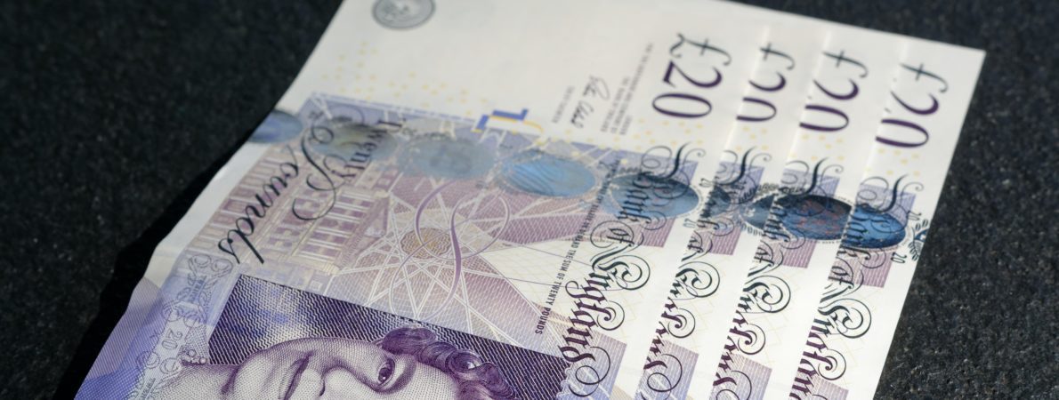 Four £20 notes lying on a table