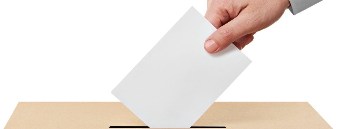 A ballot paper is being dropped into a ballot box