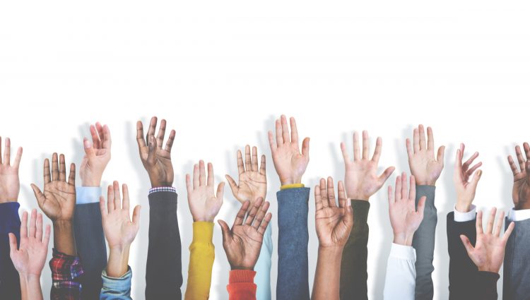 Several hands raised up in front of a white background