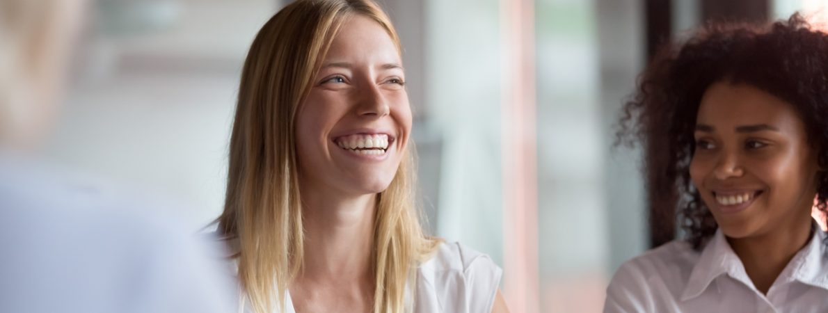 Two young businesswomen during a meeting smiling