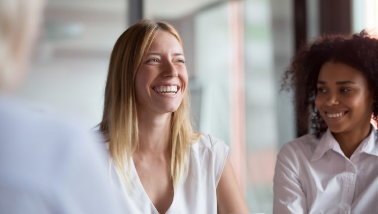 Two young businesswomen during a meeting smiling