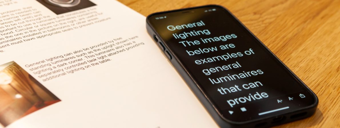 A phone and a textbook on a wooden table