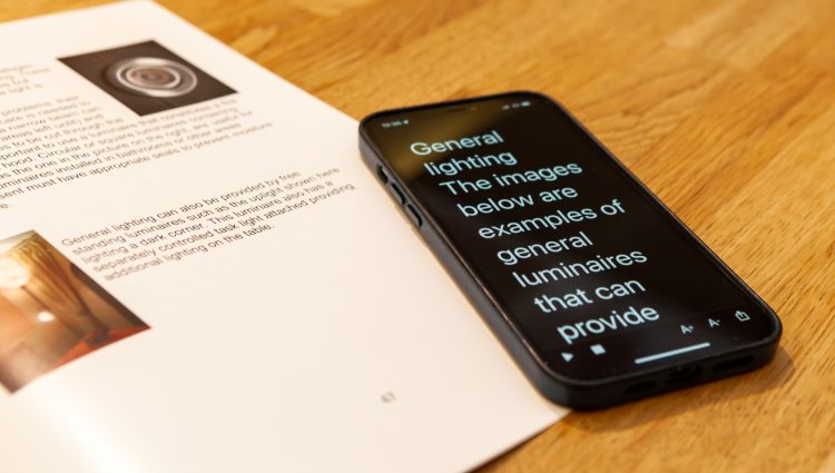 A phone and a textbook on a wooden table