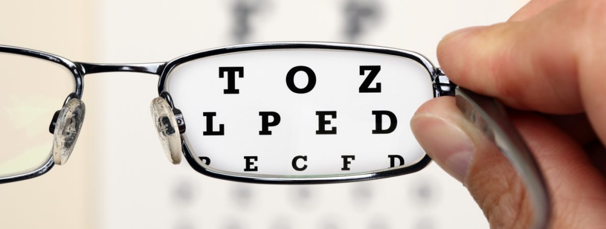 Looking through glasses at an eye test board with letters