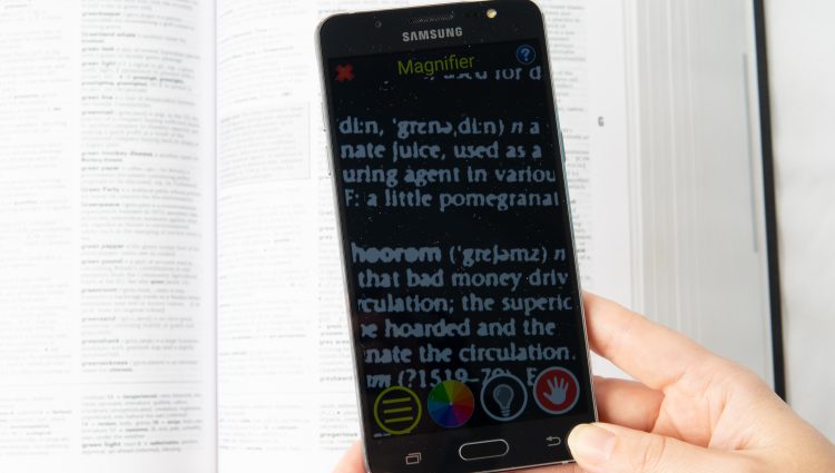 Person's hands holding a Samsung phone using magnification