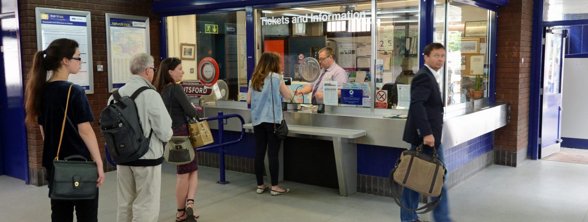 Queue of people waiting at a railway station ticket office