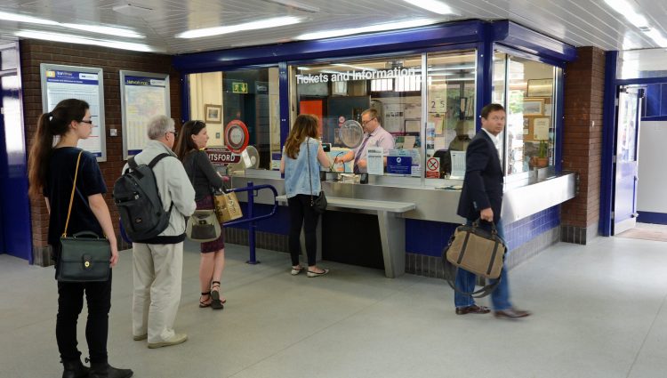 Queue of people waiting at a railway station ticket office