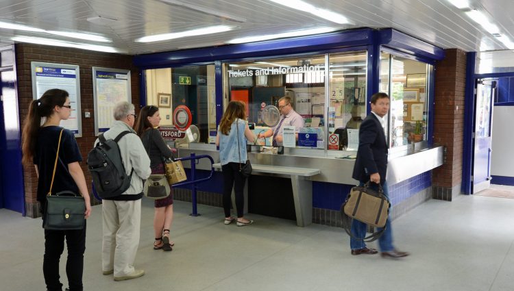 Queue of people waiting at a railway station ticket office