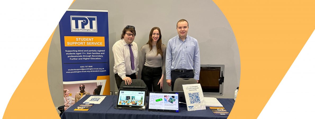 Three members of our Student Support Service team standing behind a table. Next to them there is TPT's banner and many flyers and two tablets on the table in front of them.