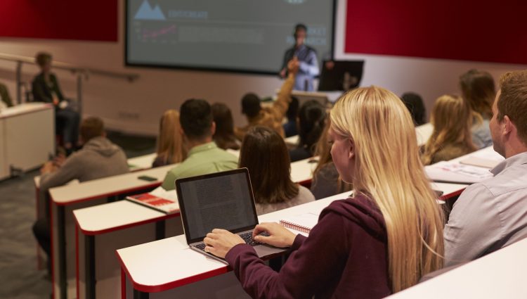 Student in front of her laptop in a lecture theatre