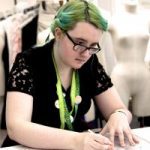 A picture of Rowan sitting on a desk, drawing