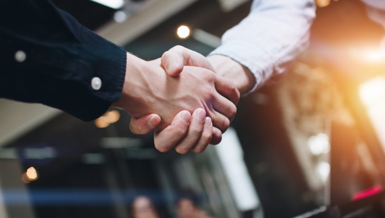 A close-up of a handshake between two males