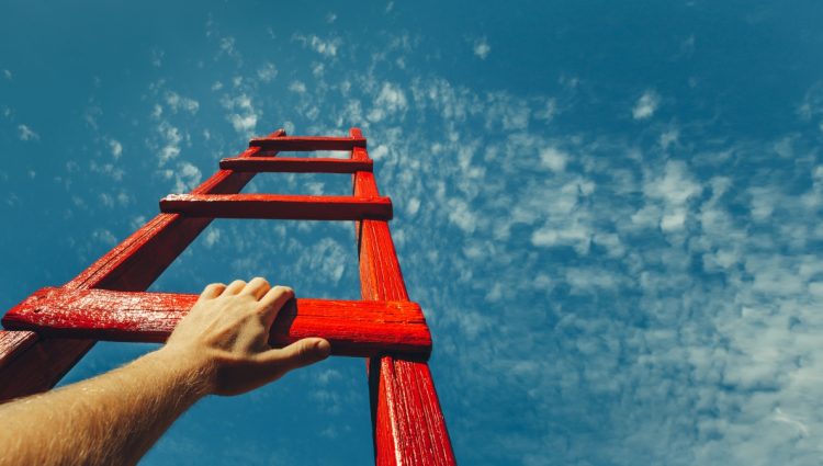 Man's Hand Reaching For Red Ladder Leading To A Blue Sky Shutterstock 24 lr